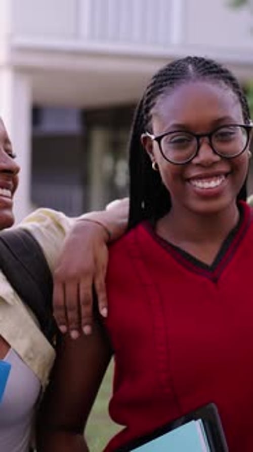 Retrato: Jovens alegres e simpáticas colegas de classe, apoiando-se umas nas outras e olhando para a câmera ao ar livre