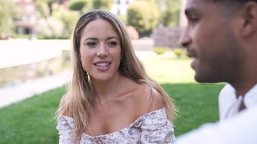 Happy Woman Listening to Man Talking at City Park During Daytime