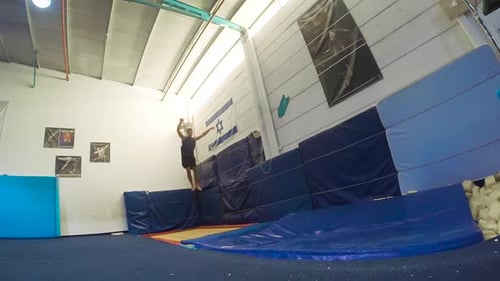Man Does Backflip in Indoor Trampoline Gym