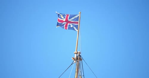 British flag waving on a pole against clear sky
