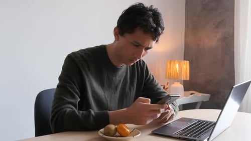 Home office worker concerned with a text message on his phone