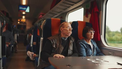 Älteres Ehepaar mit Brille schaut bei Bahnfahrt aus dem Fenster