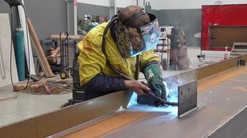 Welding Man Wearing Gloves and Mask Protection in Workshop