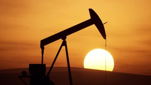 Pumpjack Operates At Sunset In A Serene Oil Field Landscape
