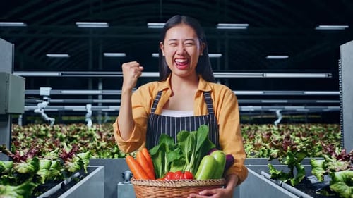 Happy Asian Female Farmer With Vegetable Basket Celebrating In Smart Farm