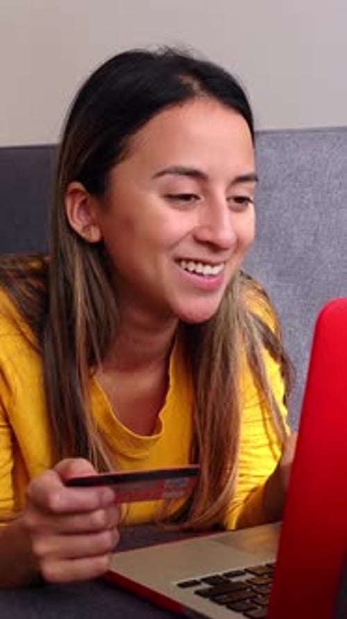 Happy Young Girl Doing Online Shopping Through Laptop and Credit Card at Home
