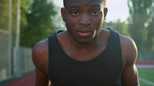 African American Ethnic Man Guy Runner Jogger Sprinter Running on Race Track Outdoor Stadium Sport