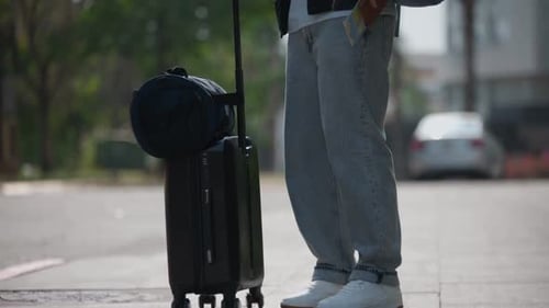 Latin Male Traveler Walking with Suitcase in Urban Area