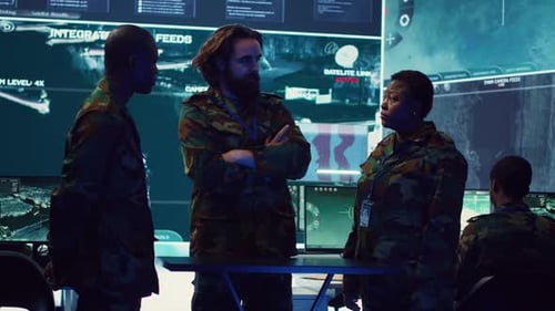 People in Camouflage Clothing Confer in Monitoring Station