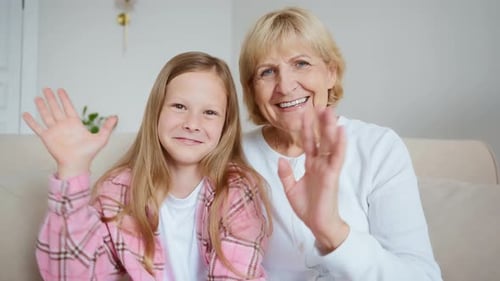 Grandmother and Granddaughter Waving From Home