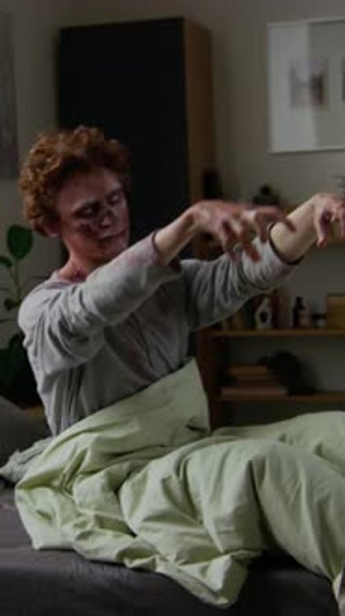 Une goule masculine en pyjama ensanglanté sort du lit et essaie de vérifier son smartphone