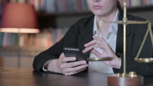 Close Up of Female Judge using Smartphone in Court, Scale of justice