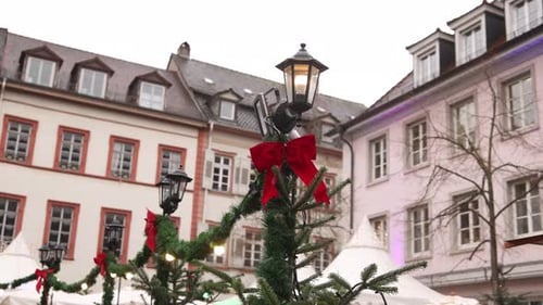 christmas red bow and green tinsel on lamp post in market square in european town at a Festive Chris