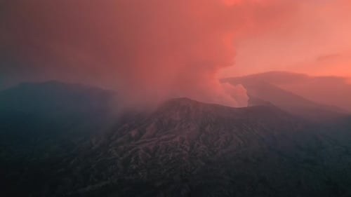 Epic Pink Sunset with Clouds and Smoking Mount Bromo Volcano at EastJava Indonesia Aerial Drone View