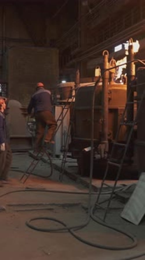 Foundry Workers Casting Molten Metal Into a Mold Stock Clip