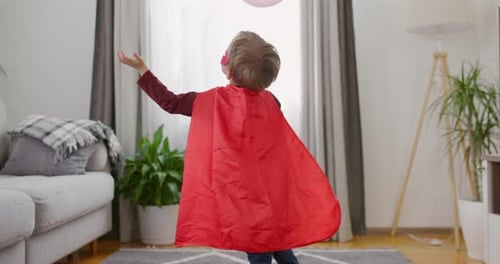 Young Child Playing with Balloons in Living Room