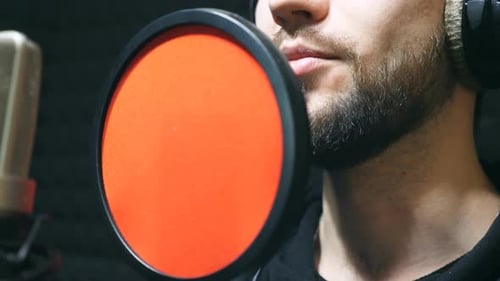 Unrecognizable Male Singer in Headphones Singing Song at Sound Studio
