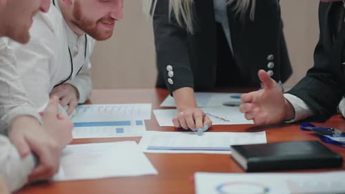 Office Workers are Discussing Plan of Development Business in Meeting Closeup of Table with Charts