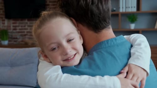 Loving Girl Embraces Father in Cozy Living Room