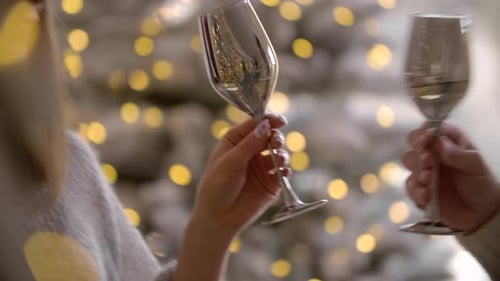 Homem e mulher tilintam óculos durante a celebração da festa de Ano Novo