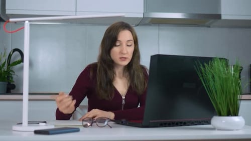 Woman Works on Laptop During Video Call