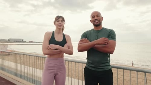 Confident male and female athletes cross their arms on their chests