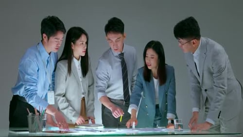 Business Team Collaborating on Project Around Glass Table