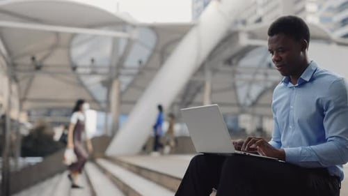 Side View of the Handsome Positive Guy Remote Working on Laptop While Sitting Outdoor
