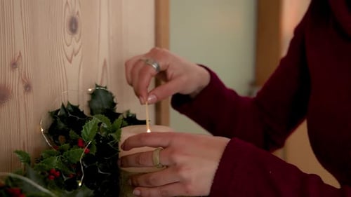 Woman Lights Candles for the Christmas Holidays