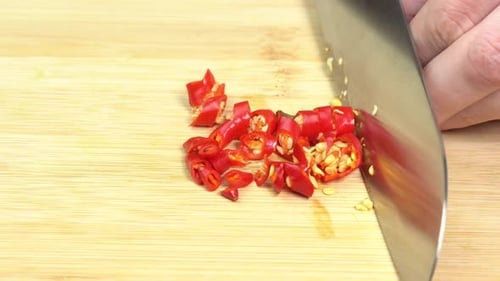 Mit einem Messer geschnittene Chilischote auf einem Holzschneidebrett. Konzept für scharfes, würziges Essen