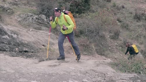 Man and woman hiking on a rough terrain in nature. Couple on a hiking adventure.