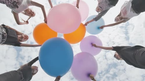 Friendly Girls Connect Big Balloons Together in the Park