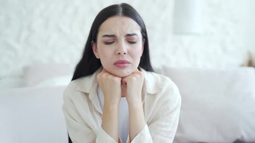 Sad Woman Resting Chin on Hands Indoors