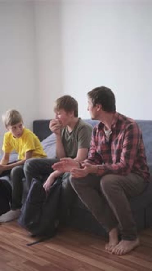 Father Helps His Two Sons Get Ready for School at Home