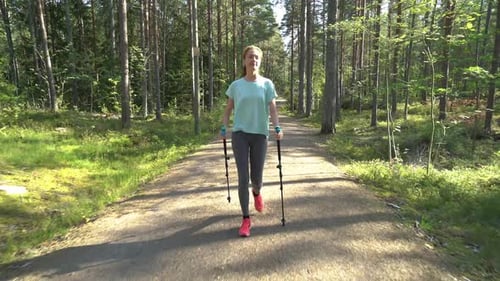 Active Woman Doing Nordic Walking in a Park
