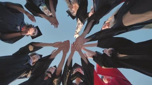 Graduating Students Join Hands in Celebration Outdoors