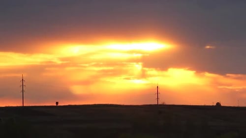Die
Sonne geht langsam über der grünen Wiese in der Nähe eines kleinen Dorfes unter. Vorbeiziehende Wolken bedecken den Sonnenuntergang!