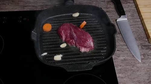 A Piece of Juicy Beef is Cooked with Vegetables in a Frying Pan