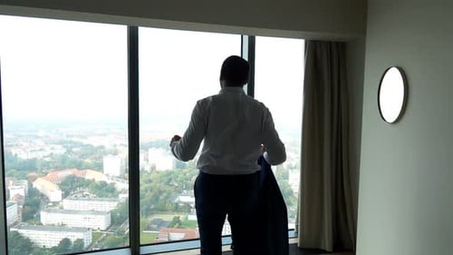 Man Stretching Arms Taking Off Suit Jacket Indoors