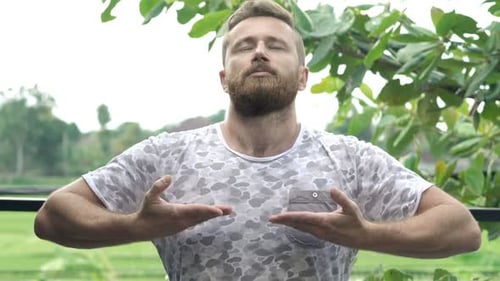 Young Man Doing Breathing Exercise on Terrace in Garden 30s