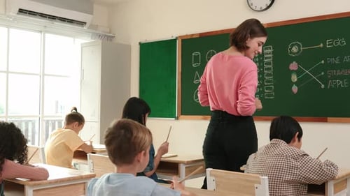 Teacher Helping Students in Elementary School Classroom