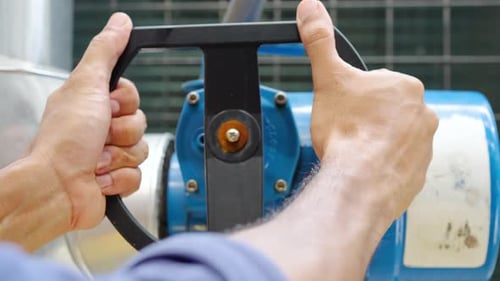 Hands close-up of male technical foreman inspects maintenance turning cut-off valve at plant
