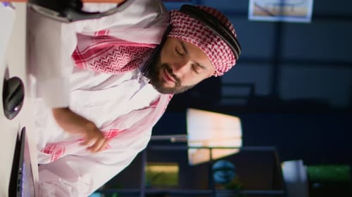 Man Talking on Phone and Using Laptop at Desk