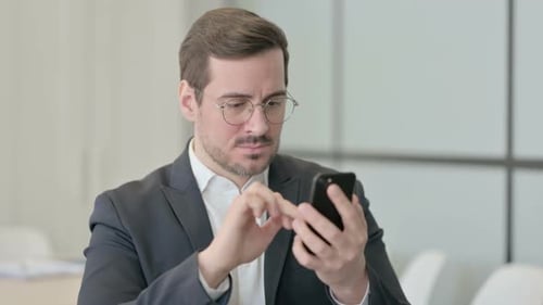Portrait of Businessman Reacting to Loss on Smartphone