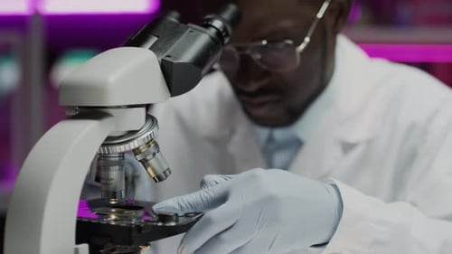 Scientist Using Microscope in Brightly Lit Lab