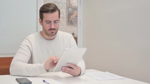 Middle Aged Man Using Digital Tablet in Office