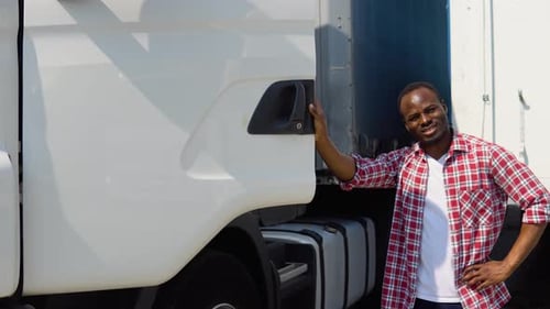Positive African American Truck Driver Posing with Trucks Happy African Truck Driver Loving His Job