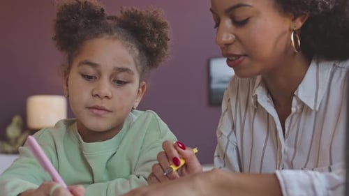 Girl Doing Homework with Woman Helping