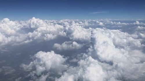 Majestic view of fluffy clouds from above, clear blue sky, aerial perspective