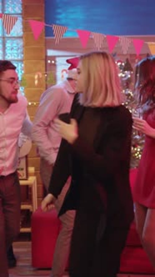 Friends Dancing at Christmas Party with Santa Hat
